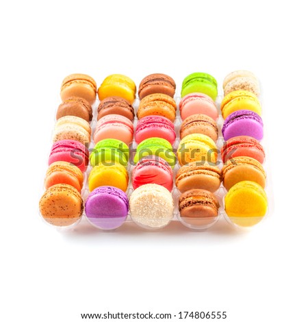 Traditional french colorful macarons in a rows in the box on white background. There are sweet meringue-based confection which are often confused with the macaroons.