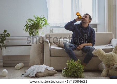 Handsome depressed man drinking alcohol at home.