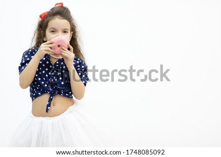 Little model posing for a photo with donut and having fun.