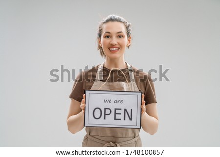 Small business owner smiling and holding the sign for the reopening of the place after the quarantine due to covid-19.
