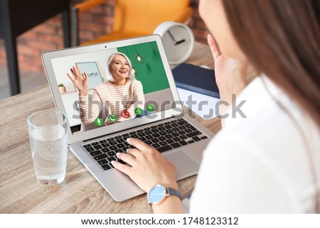 Young woman having video chat with her grandmother at home, focus on screen