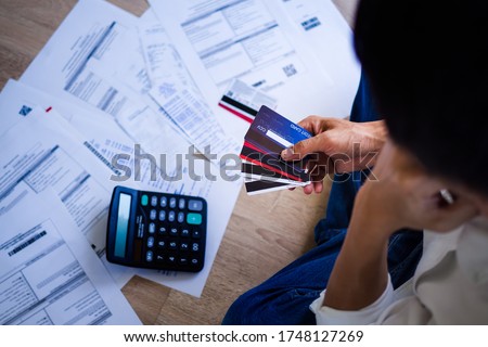 Business people are stressed about credit card debt and many bills on the floor. Men get trouble by calculating monthly expenses and then budgeting not enough money for paying debts.   Royalty-Free Stock Photo #1748127269