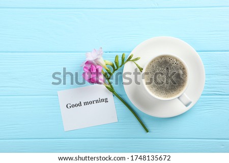 A cup of coffee, a bouquet of flowers and a card with the words "good morning". flatlay