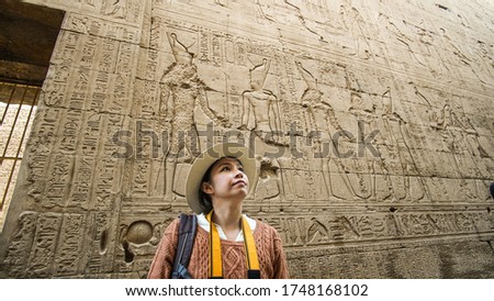 Asian tourist woman taking photo with Temple of Edfu interior Egypt Horus god landmark