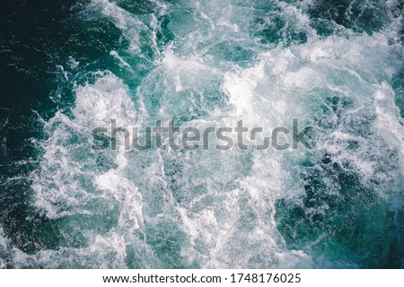 The natural background of the emerald green water spreading into waves and white bubbles as the boat sails in the morning. Feeling fresh, relaxed, and cool. There is a copy space.