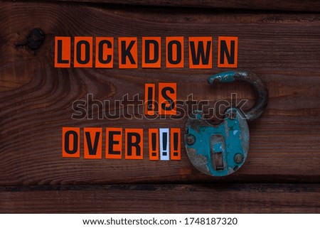 Lockdown is over sign, open lock on wooden background. Opening borders between countries. End of Quarantine COVID-19 concept creative flat lay. Social media news.