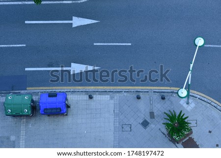 A high angle shot of the corner of the sidewalk and the asphalt street