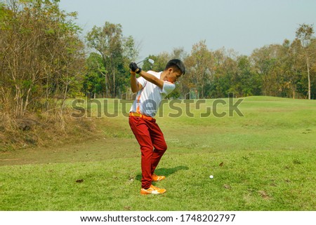 Golfer playing golf in the evening golf course, on sun set evening time. Man playing golf on a golf course in the sunset background.
