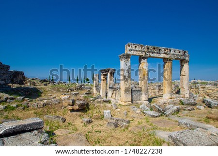 Ruins of ancient colonnade & buildings on Frontinus street in antique city Hierapolis, Pamukkale, Turkey. It was one of main streets in city. Hierapolis included in UNESCO World Heritage List Royalty-Free Stock Photo #1748227238