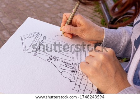 girl draws a picture with watercolor paints, close up. drawing on the open air.
