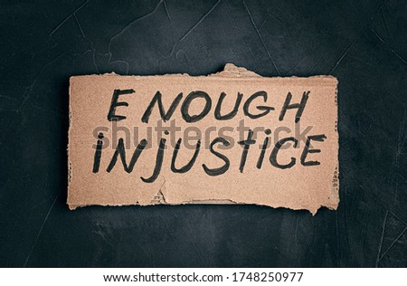 Enough injustice text on cardboard over dark background