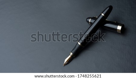 
Beautiful fountain pen. under exposed photo on a black background. Royalty-Free Stock Photo #1748255621