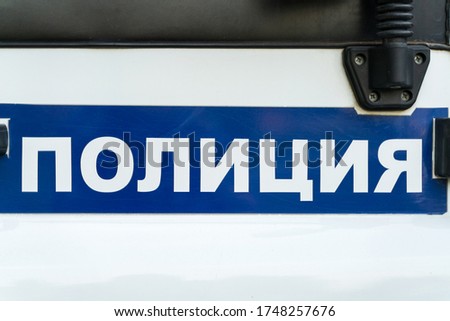 The inscription "Police" of the Tyumen region on a police car closeup. Text in Russian: Police