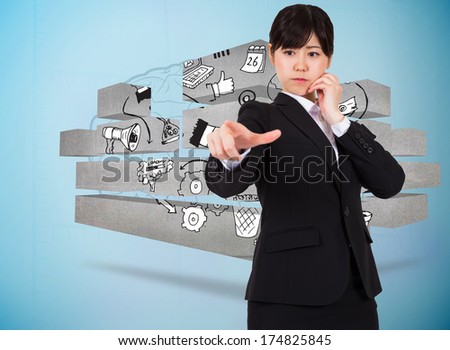Businesswoman pointing against faint brain on blue background