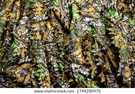 Photo of a hunting forest camouflage textured cloth.