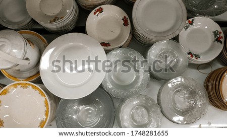 Glass plates of various types. Background stack of plates photographed from above