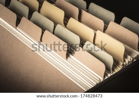 Close up side view of blank card index at slight angle.  Low saturation hues and vignette applied to give a vintage feel.  Left blank to provide copy space. Royalty-Free Stock Photo #174828473