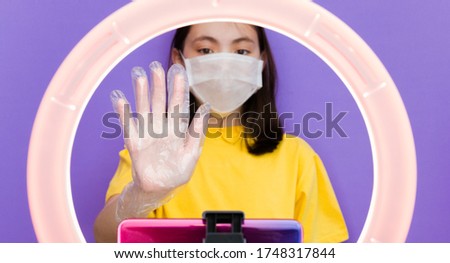 A girl blogger talks to subscribers, conducts a live broadcast, looks at the smartphone screen. Make a video in mask, call to friends and parents. stay home and quarantine.
