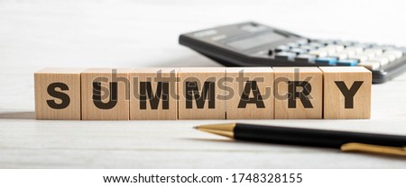 The word SUMMARY is written on wooden cubes on a light background with a pen and a calculator