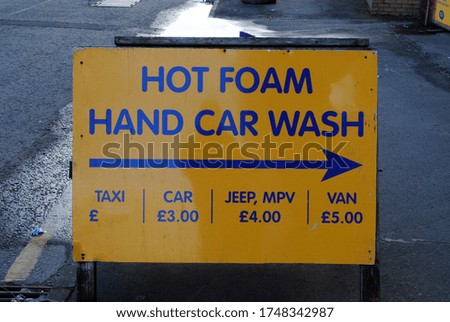Large Yellow Car Wash Sign on Pavement 