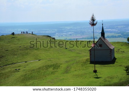
Old little church on a high green hill in the bright sun and a path
