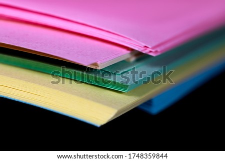 Stack of colorful papers on black background