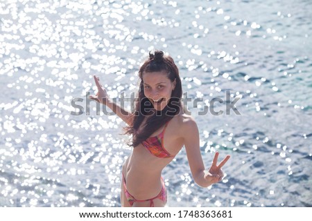 portrait of a happy woman at the beach smiling because is summer time.