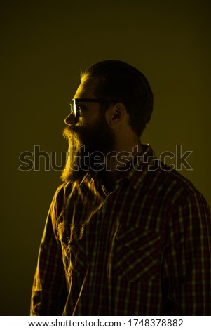 Young bearded man with crossed hands isolated on light background.