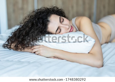 Portrait of the happy young woman having a rest on a bed at home