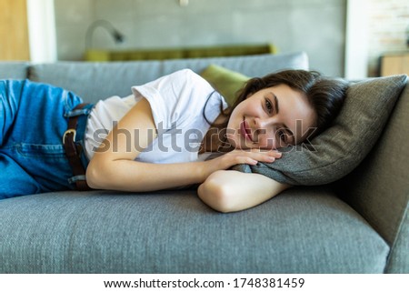 A sleeping woman is lying on a pillow on a couch