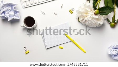 Banner, top view White office table desk. Work pace with notebook, keyboard, office supplies, yellow pen, crumpled paper balls and coffee cup on white background.