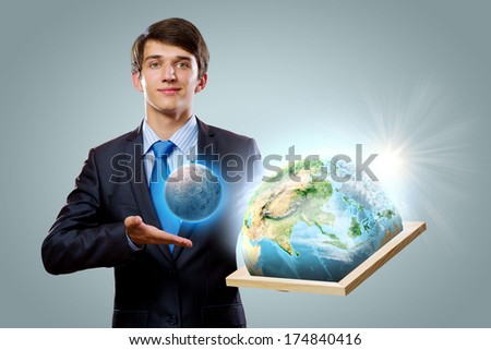 Handsome businessman holding frame with Earth planet. Elements of this image are furnished by NASA