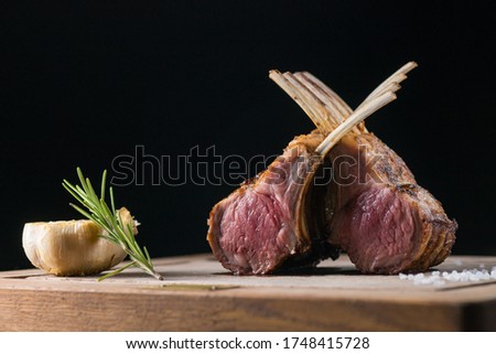 Rack of freshly grilled new zealand organic lamb cooked medium rare and put on a wooden plate and shot by professional food photographer