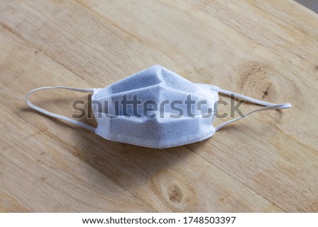Protective mask on a wooden table. 3 layers of surgical masks generally to cover the mouth and nose. Facial mask from bacteria Protection concept. Surgical mask with rubber cord, Covid 19