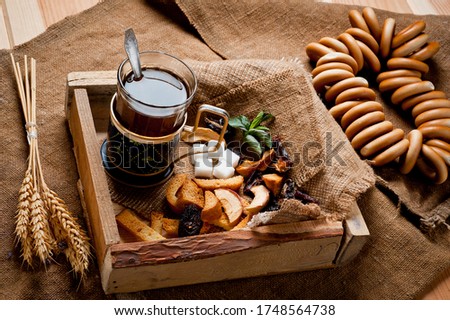 Tea in a glass cup with a cup holder, served in a rustic style, shot on a wooden surface, coated with a rough cloth. Background for traditional hot drinks.