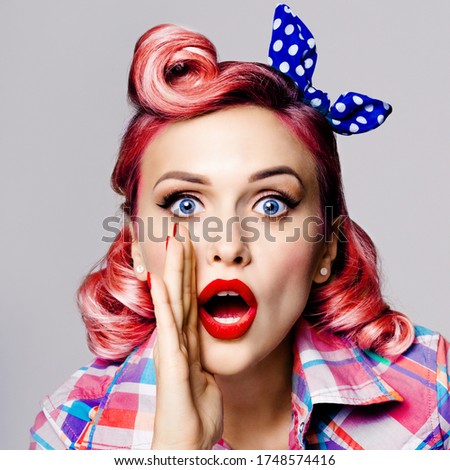 Face portrait photo of beautiful woman holding hand near open mouth and saying something. Girl dressed in pin up. Red haired caucasian model at retro fashion vintage concept, isolated on grey color.
