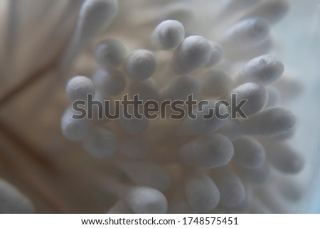 Close-up of cotton swabs in container on white background.