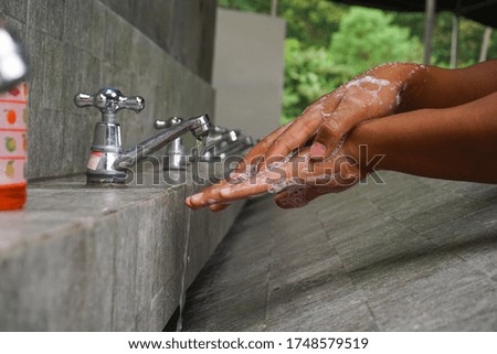 Image of a man washing his hands with soap to prevent corona virus in public places