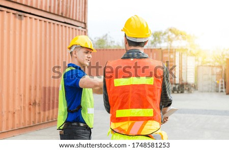 Engineer and foreman worker team checking containers box from cargo with blurred background, Teamwork concept