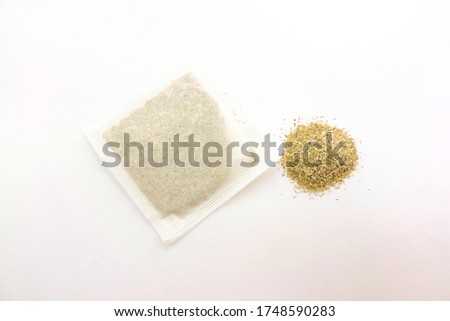     tea bag with herbs and a bunch of loose dry medicinal herbs      