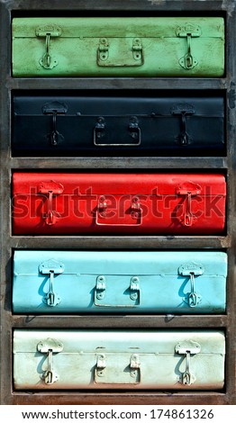 Close-up of old, worn out colorful metal locker with standard boxes. Roughly finished painted metal surface,painted metal handles. Retro style.