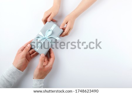 hands of a man and a reenka holding a gift top view. Father's Day Concept. place for text
