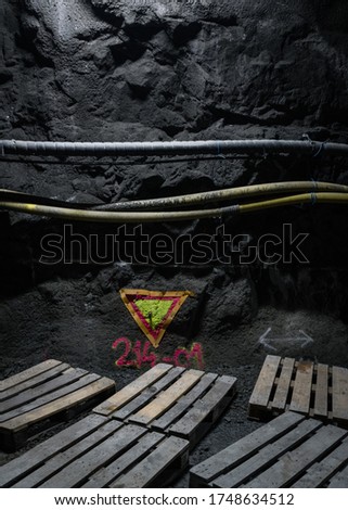 A vertical picture of pipes on a wall next to the wooden boards