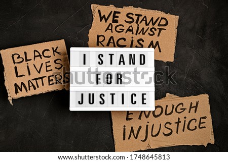 I stand for justice text on light box and other anti racism slogans over dark background Royalty-Free Stock Photo #1748645813