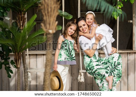 Beautiful stylish mother with daughters relax together.