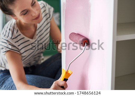 Close up of young woman repainting furniture Royalty-Free Stock Photo #1748656124