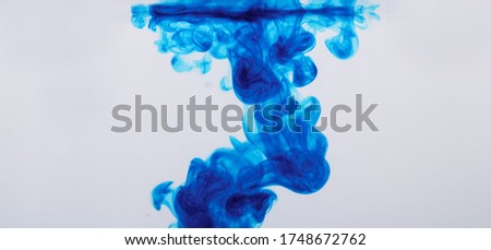 Blue ink drop in water white background