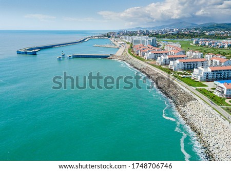 Sochi cityscape and Black sea shore from aerial view. Adler district from above. Resort town in the Caucasus mountains. Royalty-Free Stock Photo #1748706746