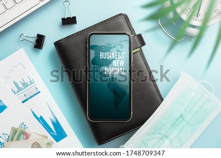 Business' new normal after corona virus covid19 pandemic background concept.  Smartphone with  notbook and medical facemask on home office working table. Royalty-Free Stock Photo #1748709347