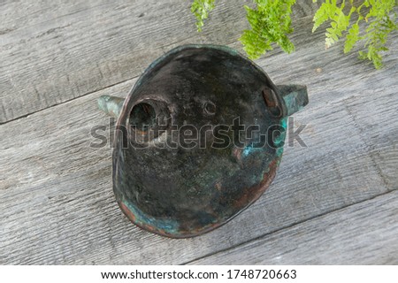 Antique brass funnel with handle on wooden background. Copy space for text, photography props. 